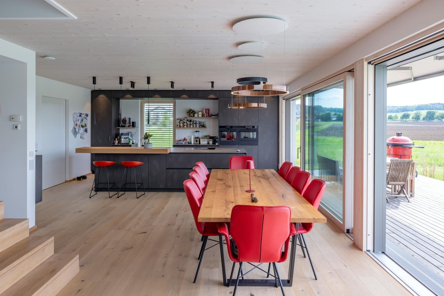 Küche Holzhaus Weilheim mit Bar und Esstisch, große Südfenster, Hebeschiebetür