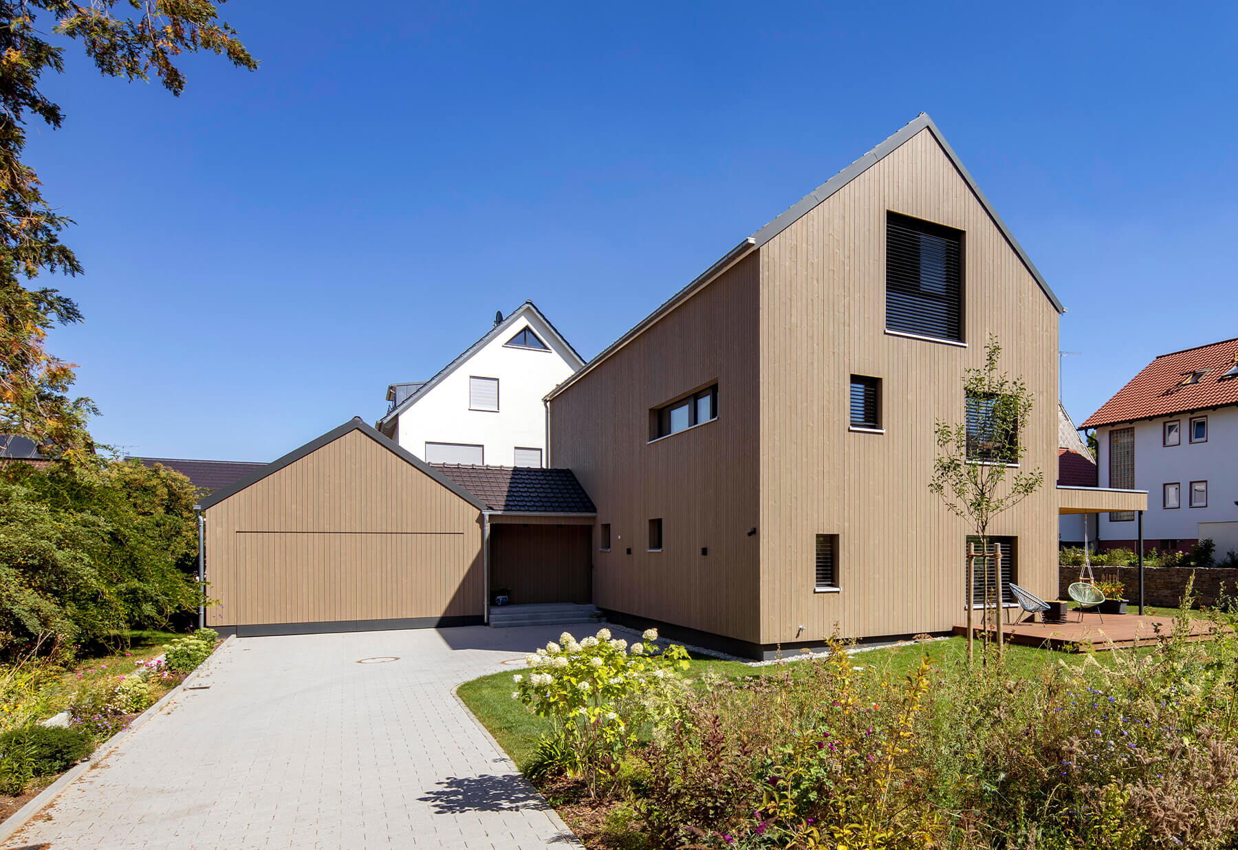 Mehrfamiliehaus, Holzfassade mit Carport