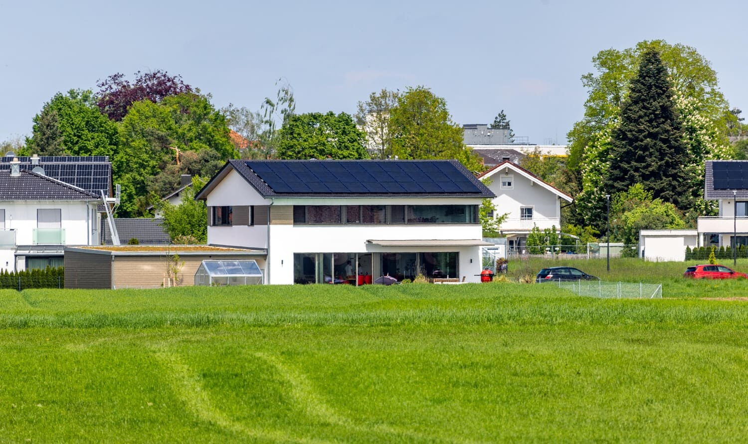 verputztes Holzhaus Weilheim Gartenansicht aus der Ferne