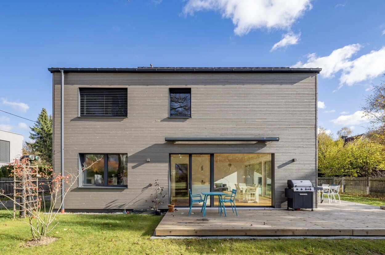 Ostseite von Holzhaus in Obermenzing bei München, Graten und Holzterrasse, bodentiefe Fenster