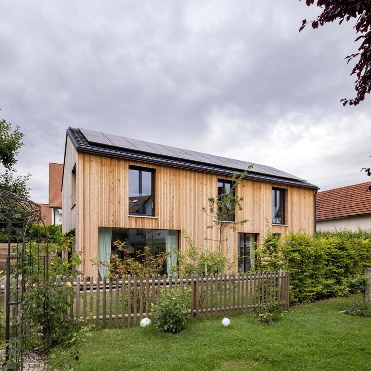 Holzständerbauweise Holzfassade, mit bodentiefen Fenstern im EG und OG, Photovoltaikanlage, Südansicht, Garten