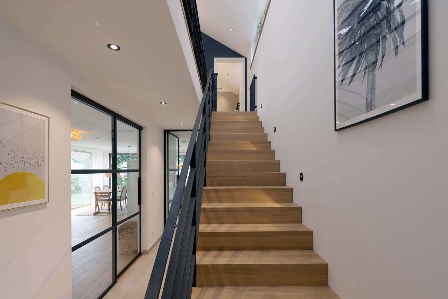 Holztreppe mit schwarzem Geländer und Loftelement