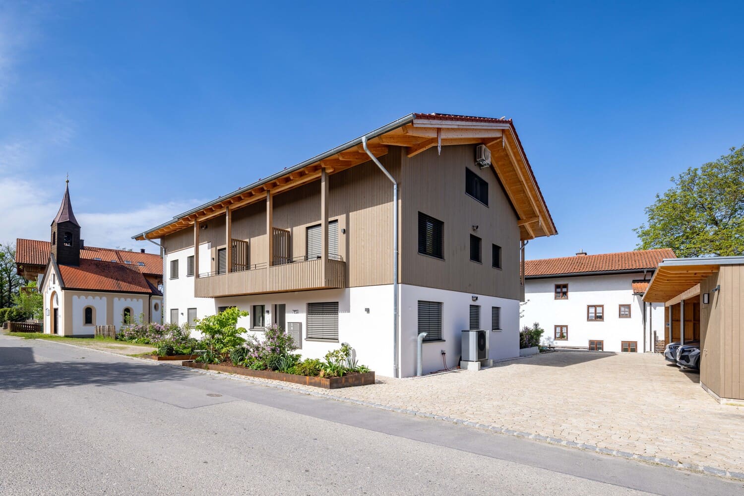Mehrfamilien Holzhaus in Übersee, Holz- und Putzfassade mit Carport